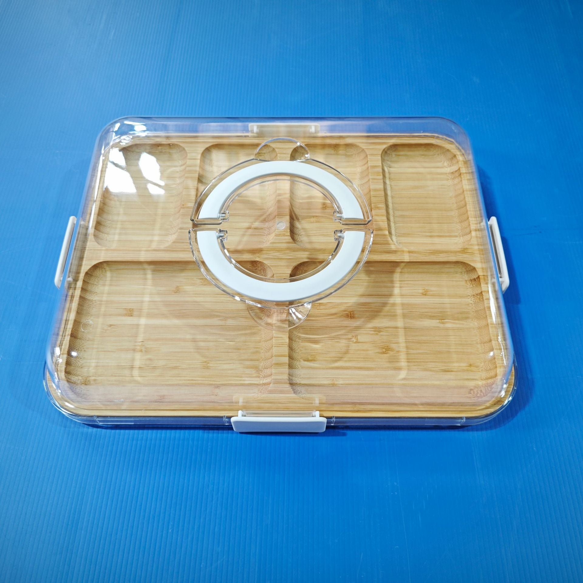 Bamboo charcuterie board with clear lid and circular handle, black latch on the front