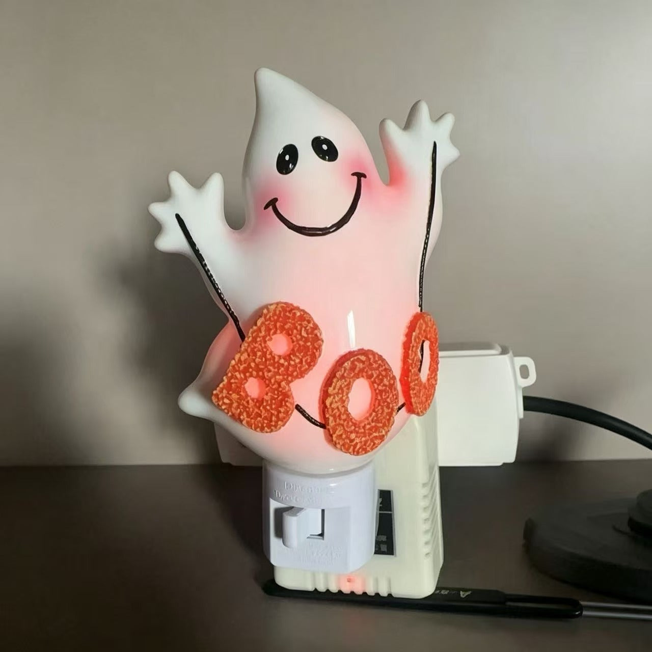 Glowing 'boo' ghost night light with smile face, orange glitter letters, wall plug