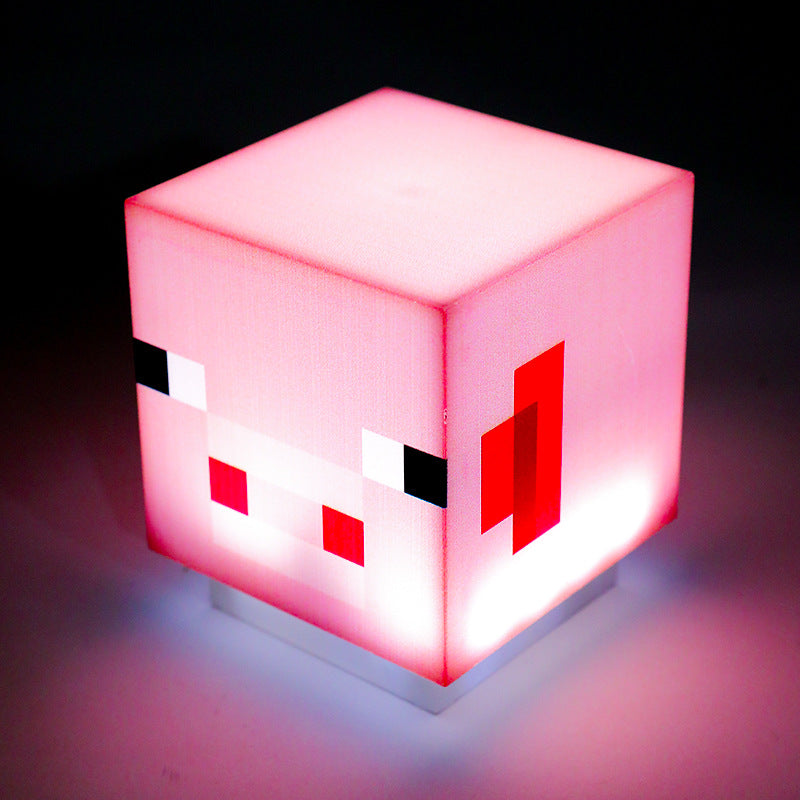Pink glowing Minecraft-style cube night light with red pixel face details
