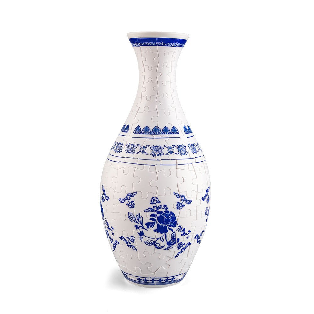 White decorative puzzle vase with blue floral motif and banded rim at top.