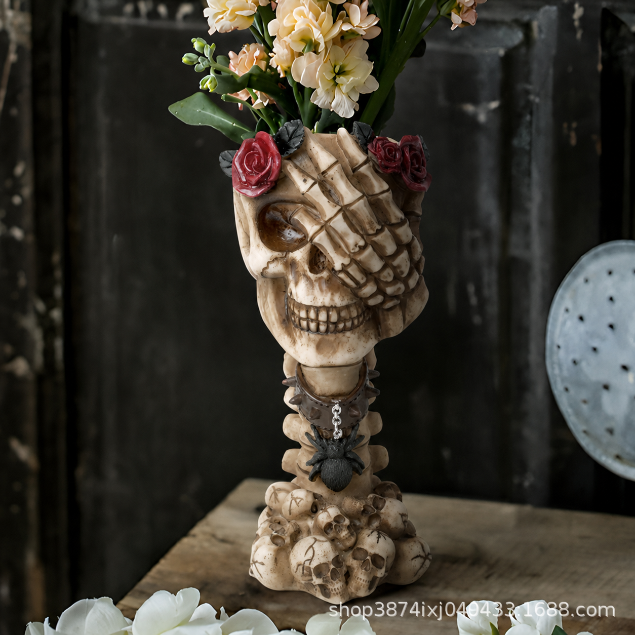 Beige skull hand vase ornament holding flowers with red roses and dark chain
