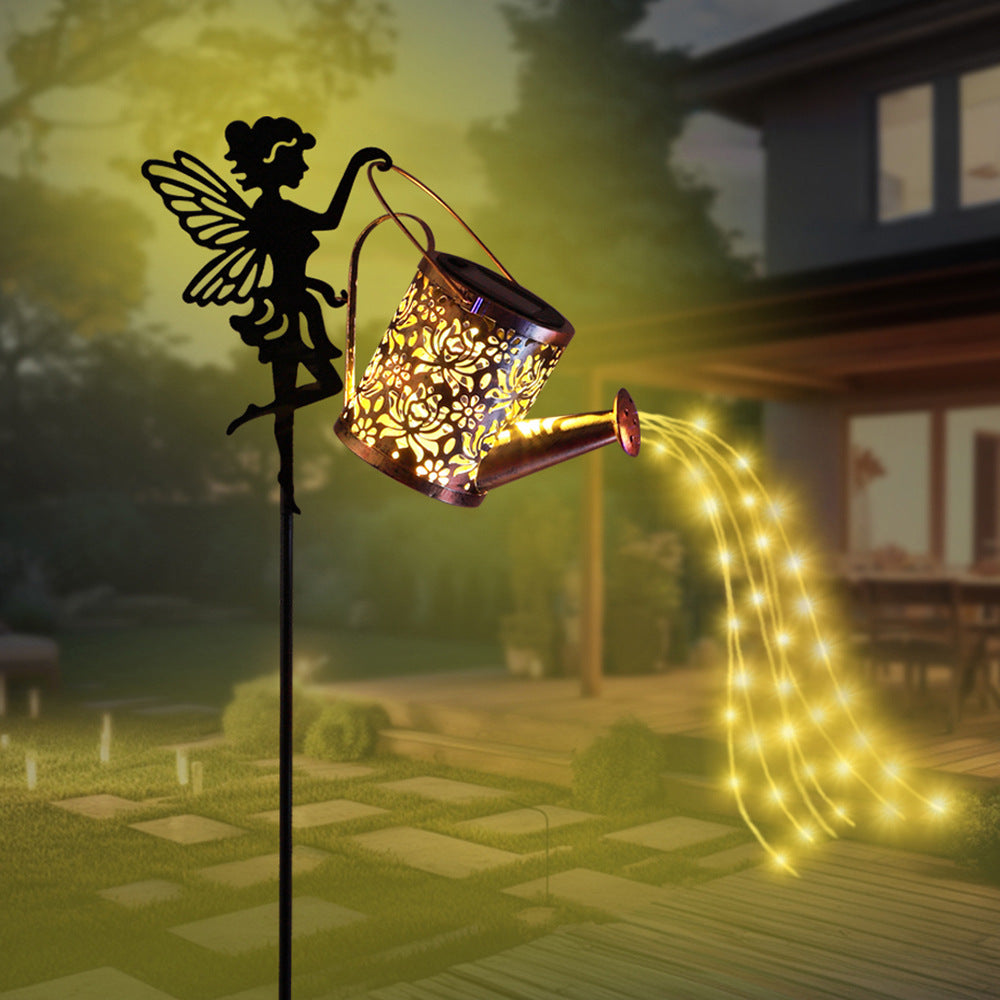 Solar fairy projection lamp glowing warm light; bronze lantern on black angel stake