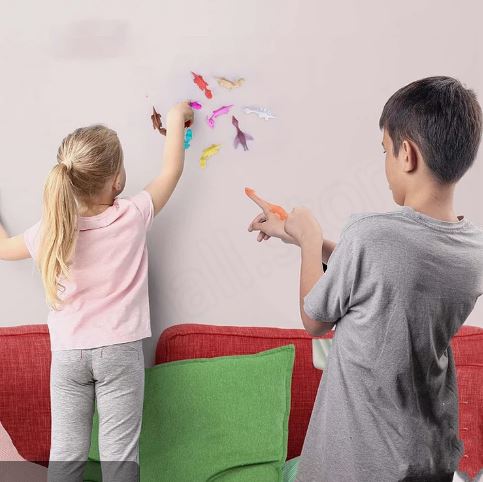 Children playing with colorful dinosaur slingshot finger toys