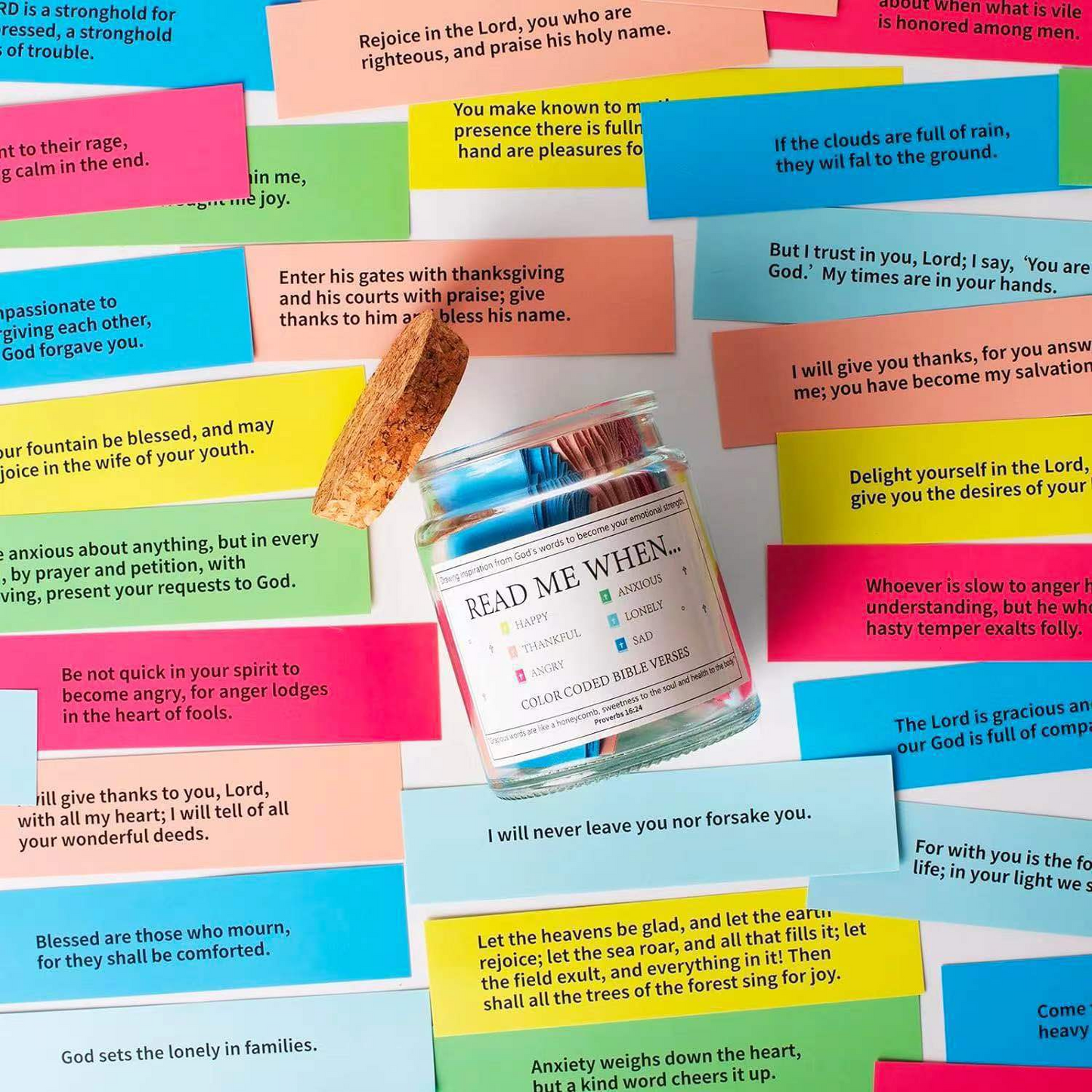 Overhead view of colorful scripture cards surrounding a small glass jar.