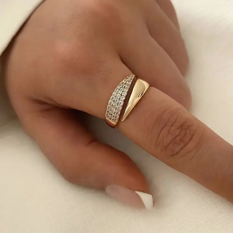 Gold-tone pavé band ring with sparkling stones on a finger, double-row style
