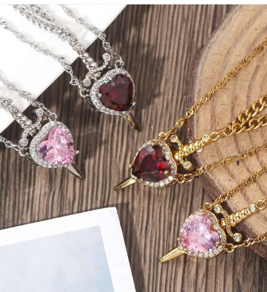 Heart and dagger pendant necklaces on chains, with pink and red heart stones