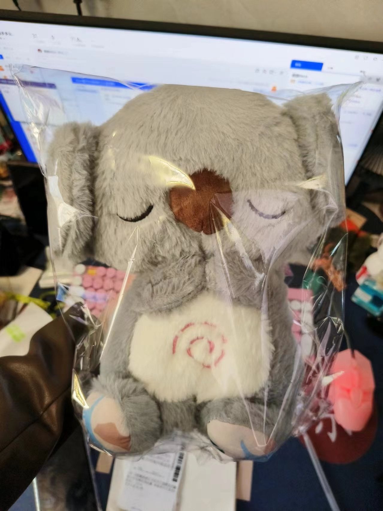 Gray koala plush baby sound machine, brown nose patch and closed eyes.