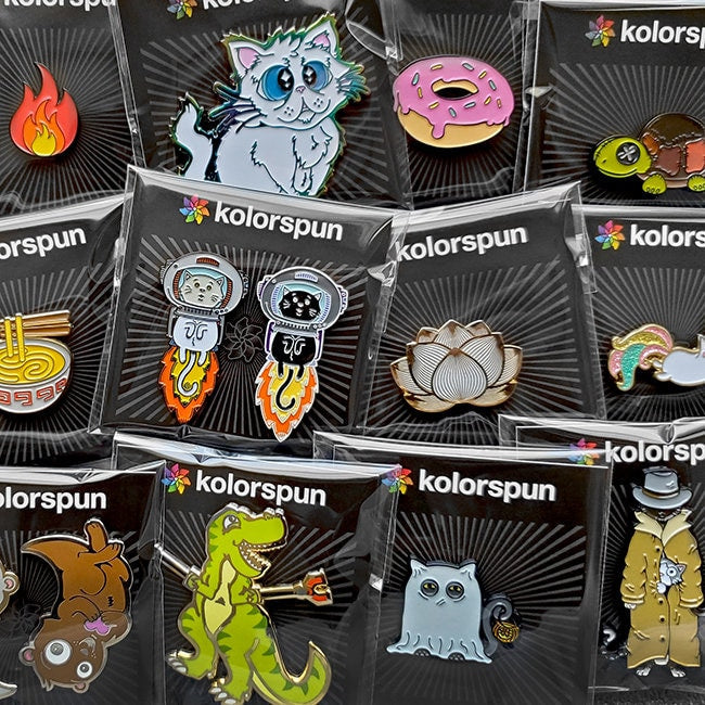 Display of colorful enamel fridge magnets with multiple character-shaped designs