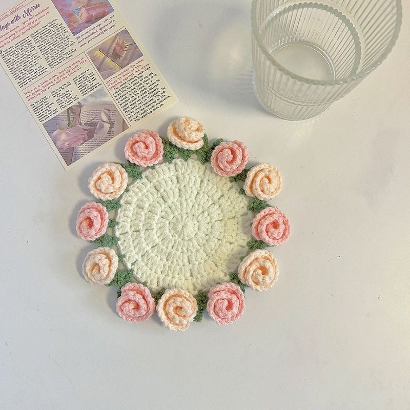 Round crocheted coaster with pale center and pink-and-orange rose border