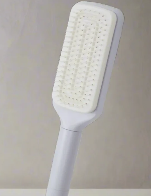 Self-cleaning hair brush with white bristle pad and pale purple handle