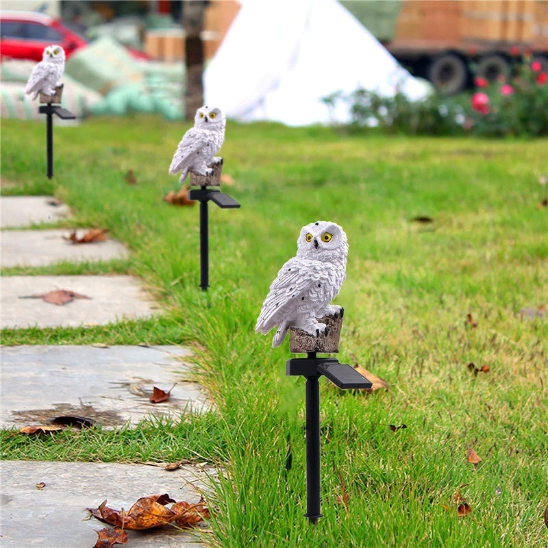 White owl garden lamp on a stake with glowing light in the base