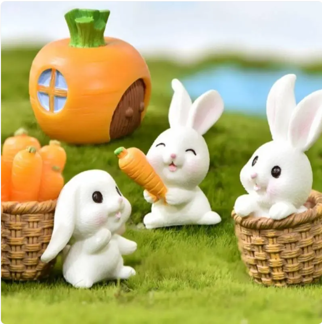 Assorted mini resin animal figurines: orange pumpkin house, white rabbits, small baskets, carrot.