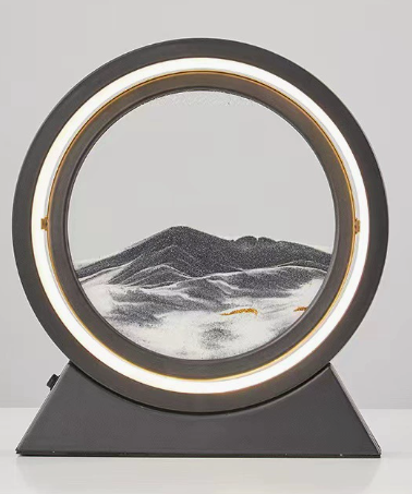 Quicksand table lamp with dark gray sand landscape in a circular lit ring and base