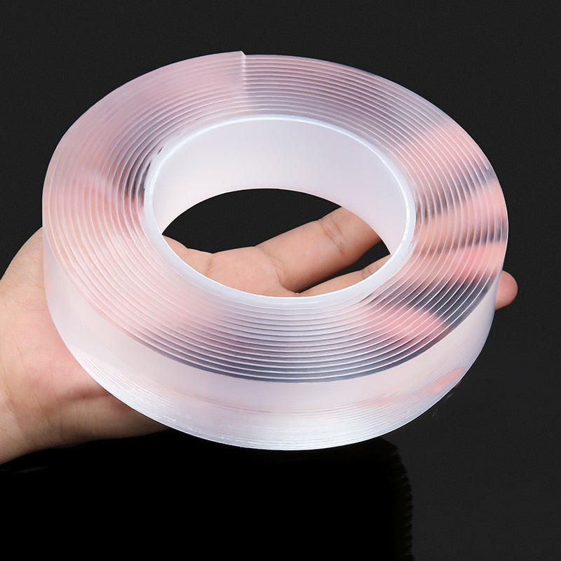 Double-sided transparent tape roll held up, showing center ring