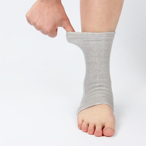 Grey ankle support sock on foot, elastic arch and heel wrap visible