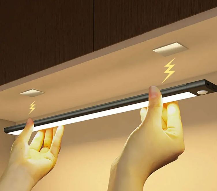Motion sensor LED light bar under ceiling with hands, warm glow