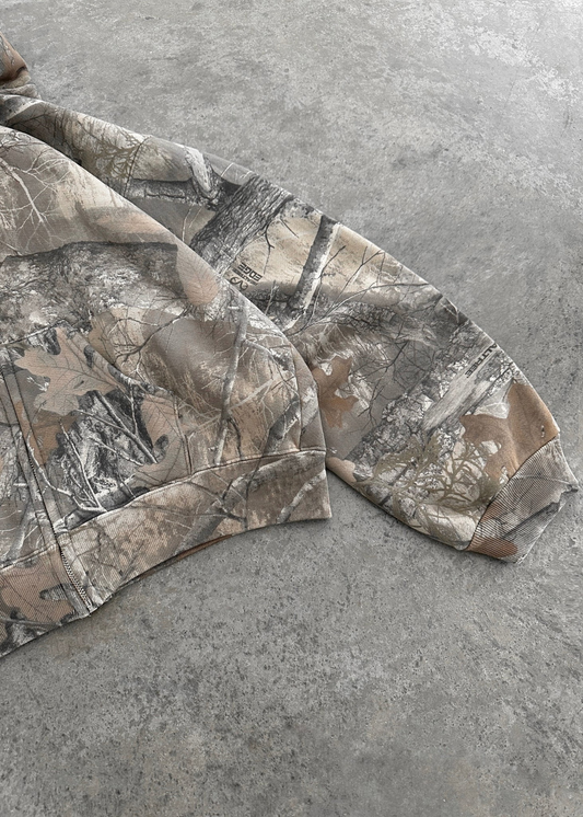 Camouflage hoodie sleeves, tree-branch print in gray and tan tones