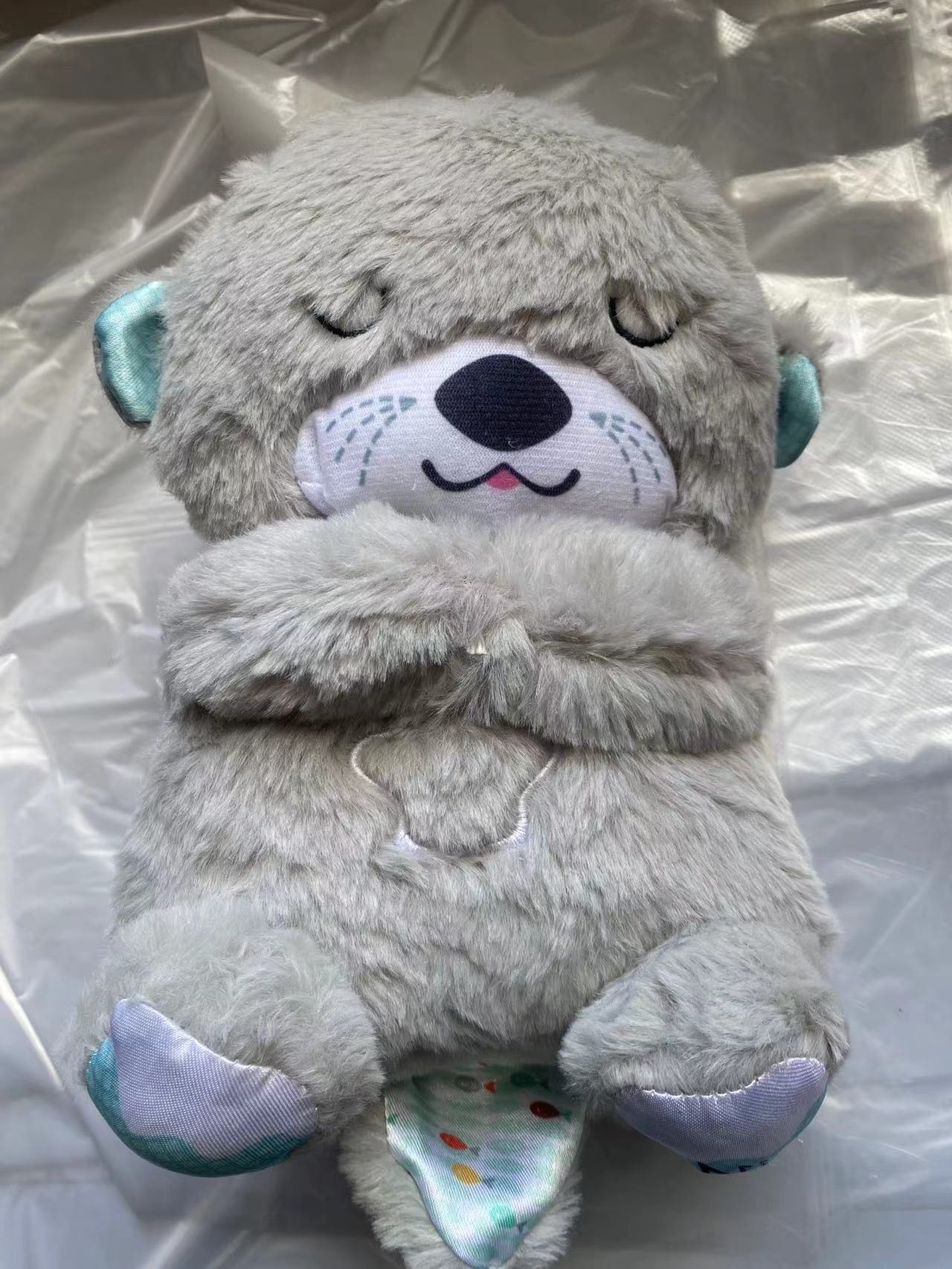 Gray plush koala baby sound machine, full-body view with teal paw details