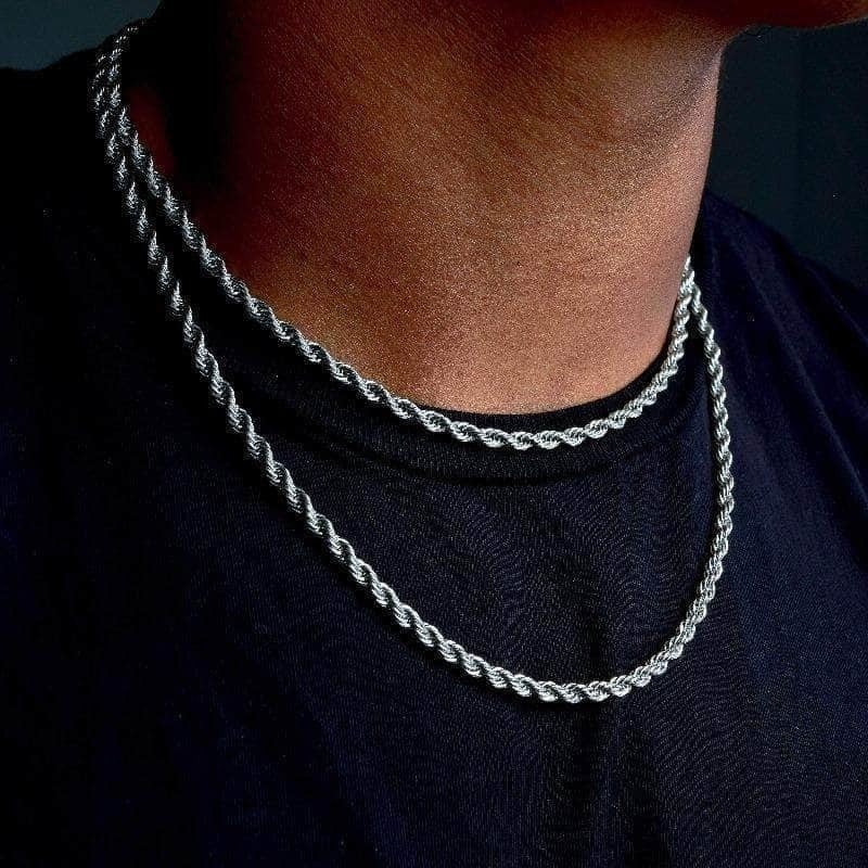 Twisted rope Figaro necklace on a dark shirt, silver-toned chain links visible at neckline