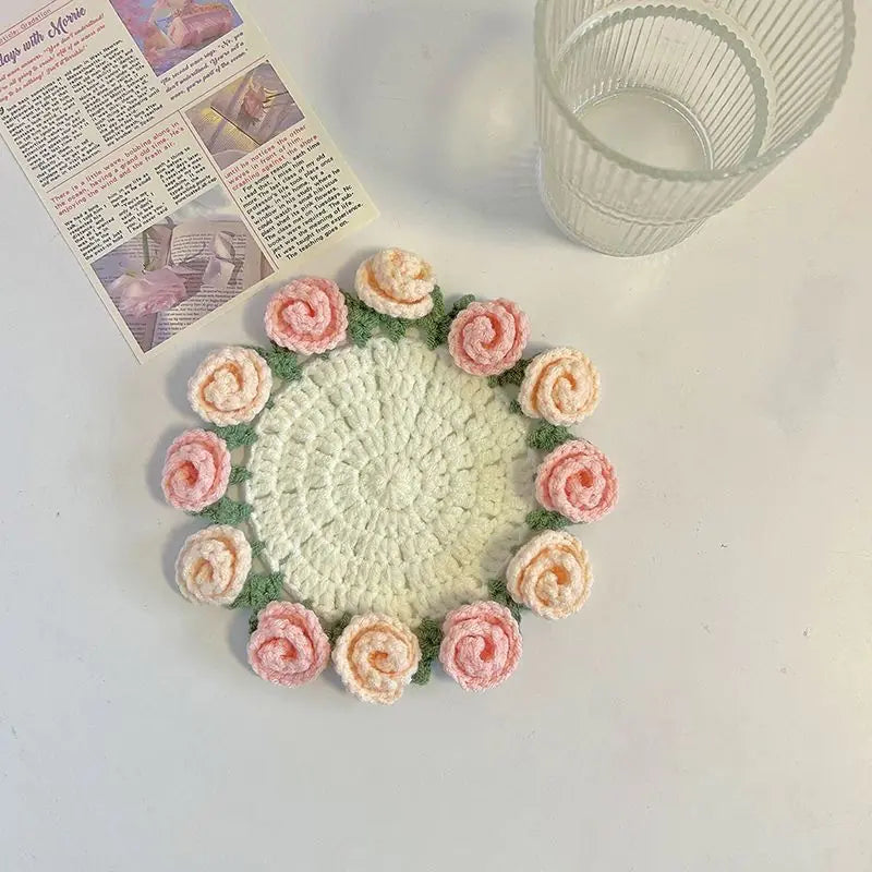 Crocheted coaster with mint center and pink-and-cream rose-like crochet circles