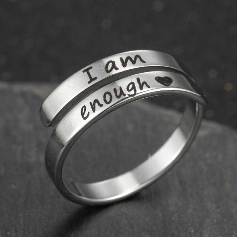 Silver-tone engraved double ring band showing cursive "I am enough" and dot accents