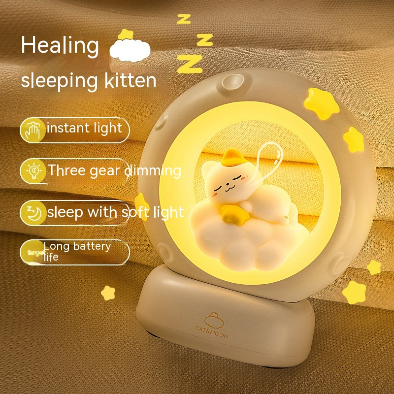 Close-up moon night light lamp showing sleeping kitten inside glowing ring on base