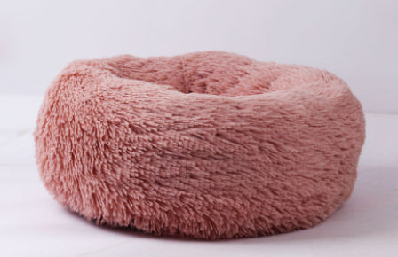 Pink plush donut pet bed with plush bolster rim and hollow center.