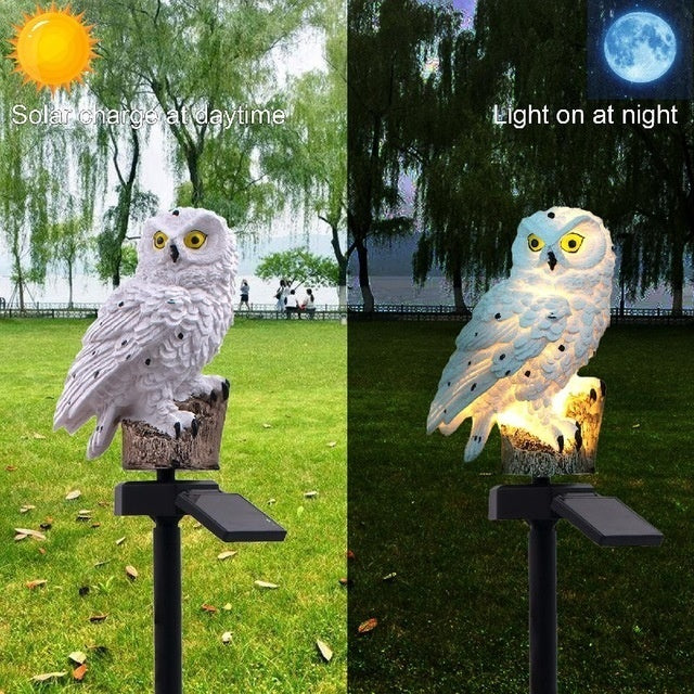 Two owl garden lamps on stakes, white and light-blue, illuminated with warm glow