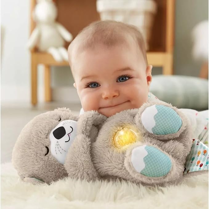 Gray plush baby sound machine held by baby, teal paw pads and soft belly light