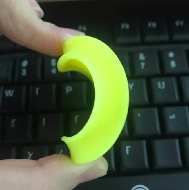 Neon yellow mini flying disc held near a keyboard, side profile with curved rim.