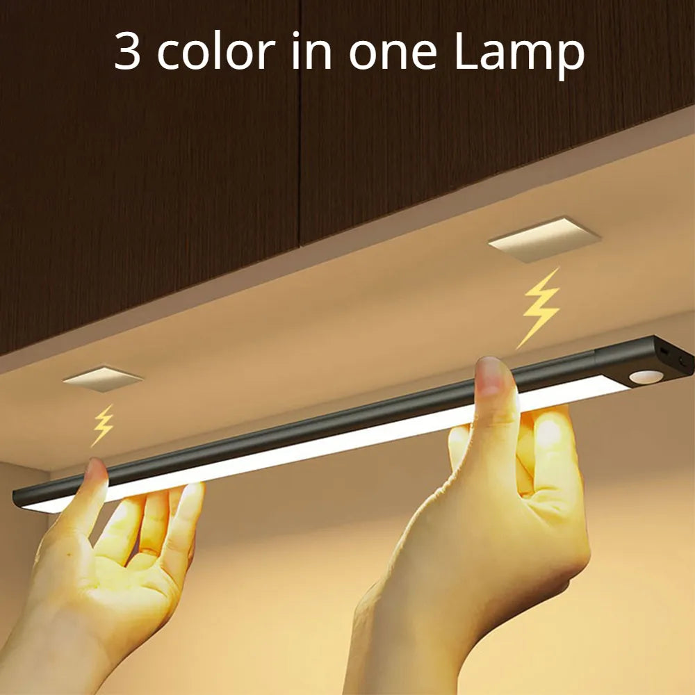 Motion sensor LED light bar under ceiling, hands near light, warm yellow glow