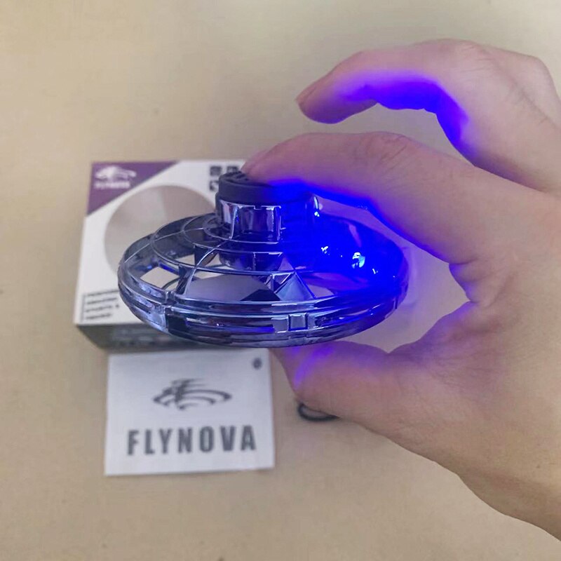 Mini UFO spinner in hand, blue LED glow around circular ring