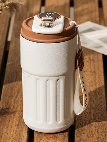 White insulated travel coffee mug with temperature display, orange lid, carry strap