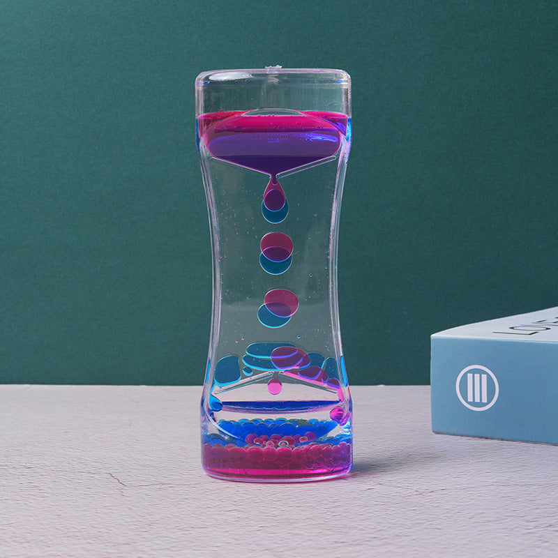 Two-color liquid hourglass timer with purple top and blue bottom, floating colored beads