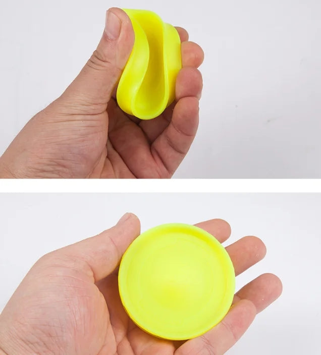 Neon yellow mini flying disc in hand, curved edge and rim visible.