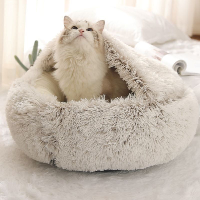 White plush pet bed with raised rim and tunnel entrance, cat resting inside.