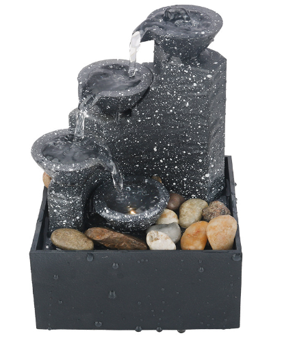 Tabletop waterfall fountain with dark stone basins and flowing water over rocks