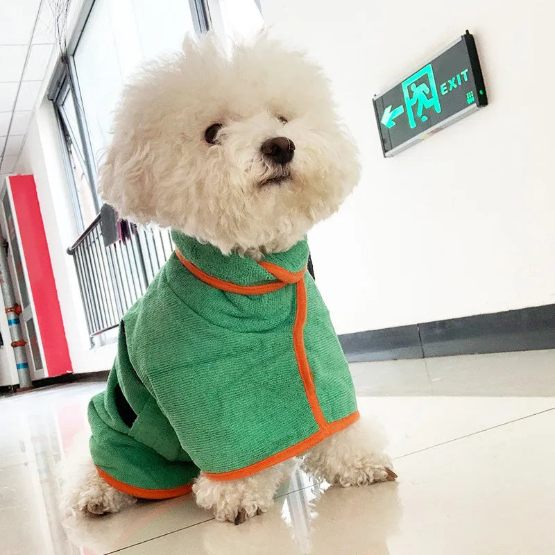 Dog wearing a green fast-drying bathrobe towel with orange trim and adjustable neck strap
