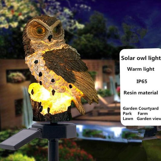 Brown resin owl garden lamp on a stake, warm light glowing from the body