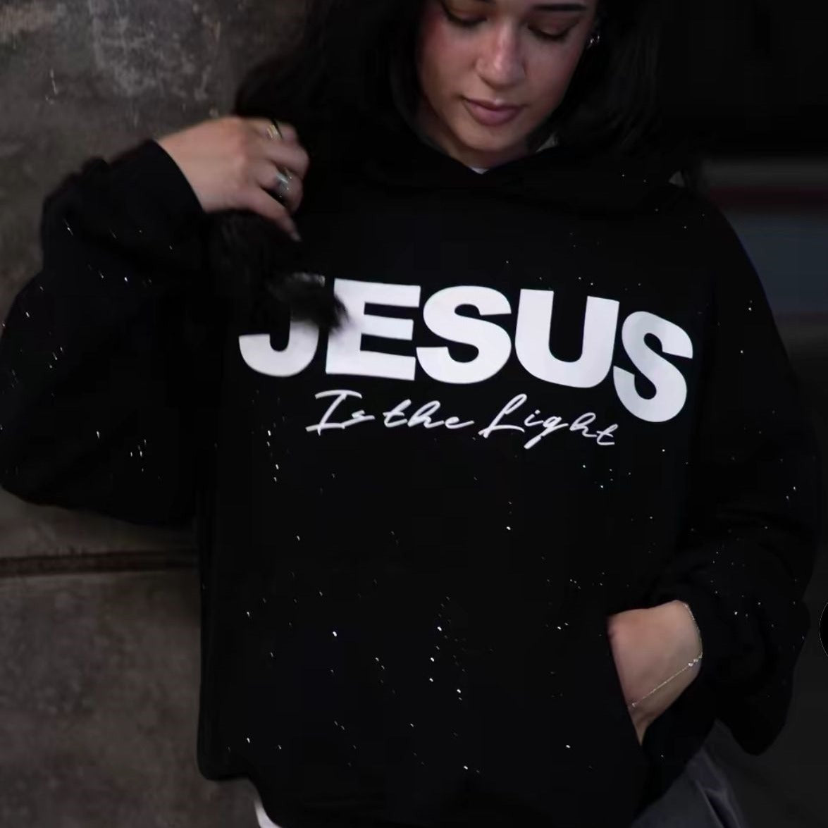 Black pullover hoodie with large white “JESUS” graphic on the front, front pouch pocket