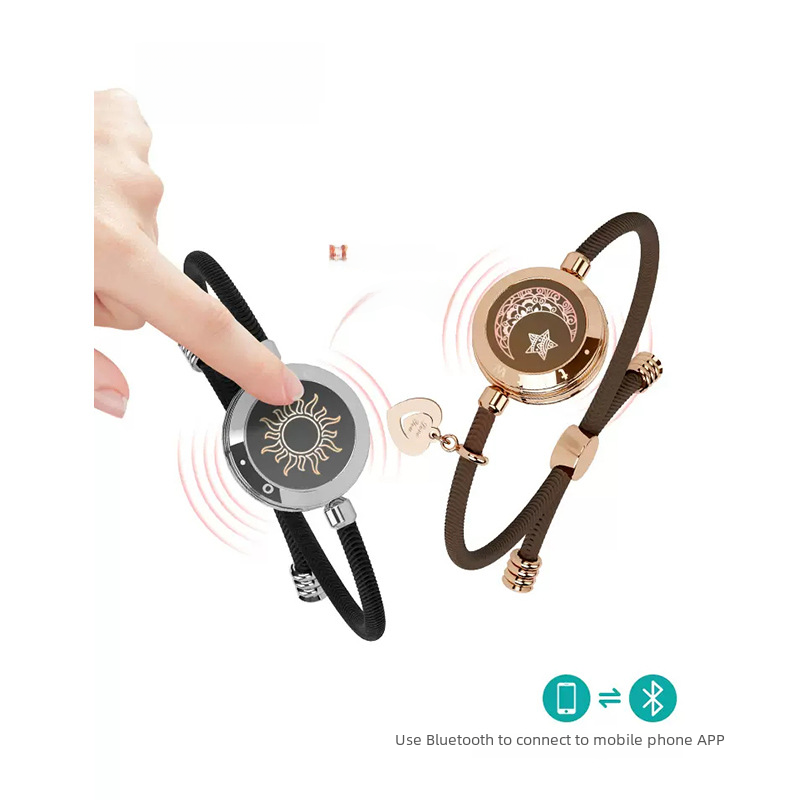 Hand tapping a black cord smart bracelet with sun dial beside a rose-gold moon bracelet