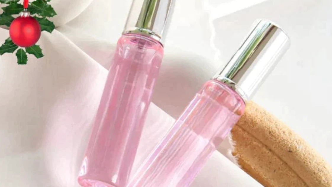 Pink perfume roller bottles with silver caps, one bottle slightly forward