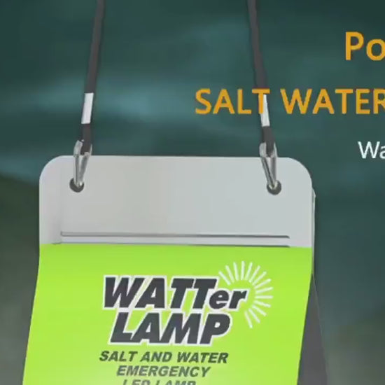 Portable saltwater lamp with a green label, hanging by black straps against a dark background.