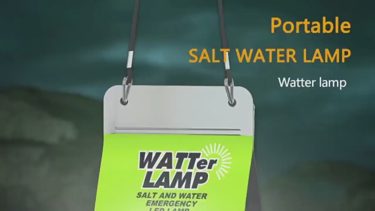 Portable saltwater lamp with a green label, hanging by black straps against a dark background.