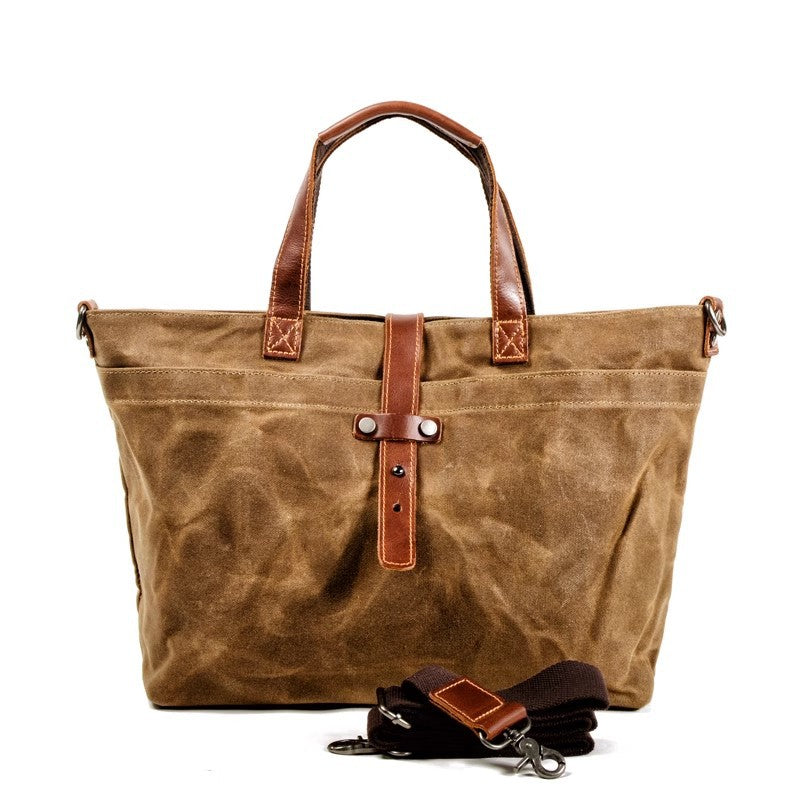Large tan canvas tote bag with leather handles, front strap detail, and accessory pouch